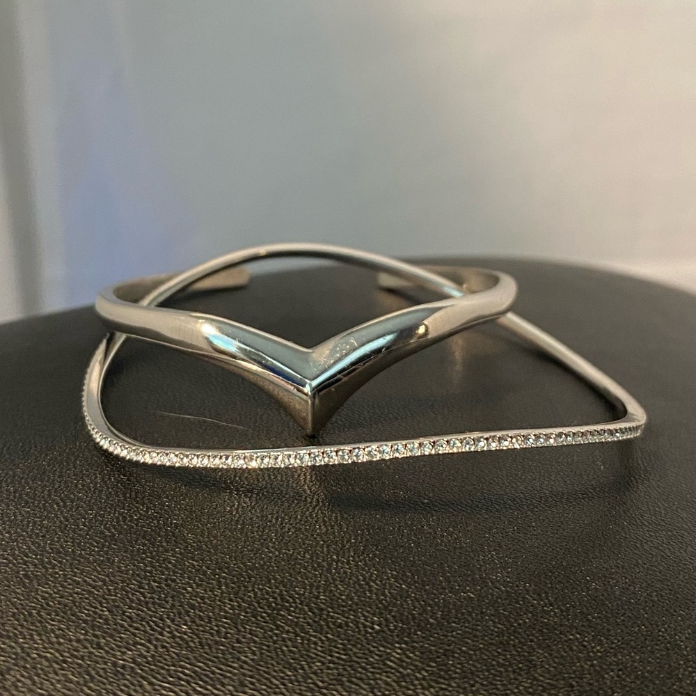 Pair of stackable petit demure cutesy thin silver tone bracelets.